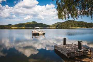 Obraz premium Beautiful waterscape with a motor boat and a forest background. Summer day. reflection in the water.
