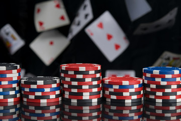 on the black mirror surface, casino chips, on the background of scattered cards
