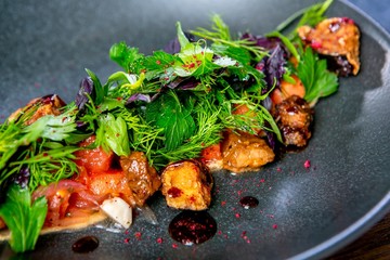 Salad with beef, eggplant and goat cheese. European cuisine. The work of a professional chef. Dish from a restaurant or cafe menu. Close-up