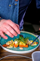 Chef decorates the salad with smoked catfish, carrots and miso sause. Master class in the kitchen. The process of cooking. Step by step. Tutorial. Close-up