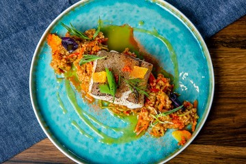 Halibut stewed in mango sauce. European cuisine. The work of a professional chef. Dish from a restaurant or cafe menu. Close-up