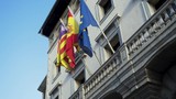 Flags of European countries on embassy house facade. Stock. Colorful banners fluttering in the wind on grey building background.