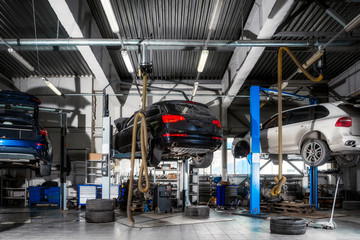 Car repair on a lift for the repair of the chassis, automatic transmission and engine in the auto...