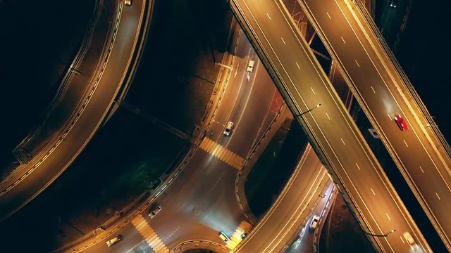 Aerial photography with quadrocopter. The camera goes down to the road. Bird's-eye view. A busy intersection in Sochi. Evening illumination of the track.