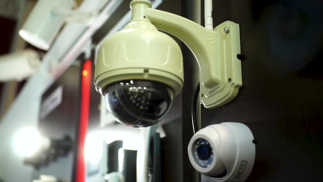 Security camera inside office building, anti-theft system, security concept. Stock. Surveillance system with green and red light stripe behind.