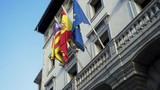 Flags of European countries on embassy house facade. Stock. Colorful banners fluttering in the wind on grey building background.