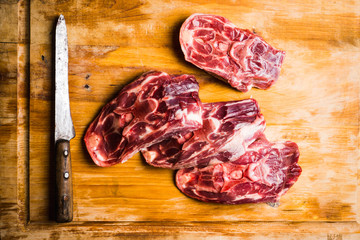 Raw meat with salt and spices on the rustic background. Selective focus.