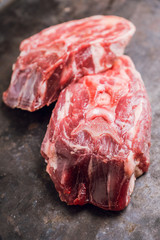 Raw meat with salt and spices on the rustic background. Selective focus.