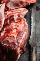 Raw meat with salt and spices on the rustic background. Selective focus.