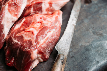 Raw meat with salt and spices on the rustic background. Selective focus.