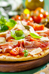 Appetizing italian pizza with prosciutto