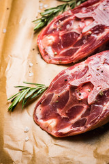 Raw meat with salt and spices on the rustic background. Selective focus.