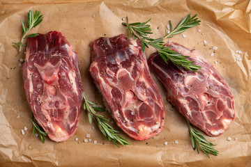 Raw meat with salt and spices on the rustic background. Selective focus.
