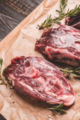 Raw meat with salt and spices on the rustic background. Selective focus.