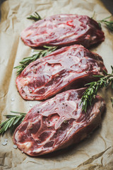 Raw meat with salt and spices on the rustic background. Selective focus.