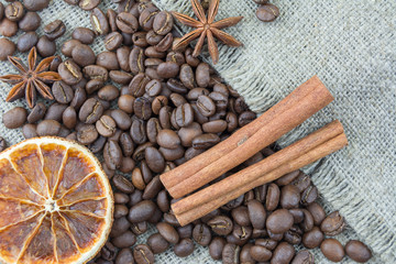 Coffee beans, cinnamon sticks scattered on the burlap.