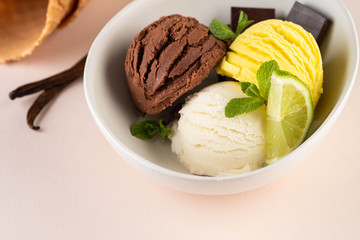 Trio of tasty chocolate vanilla and lime flavored frozen dessert in a white bowl.