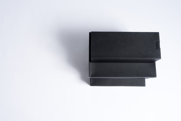 Three black paper boxes of different size. One standing on other. White background with copy space.