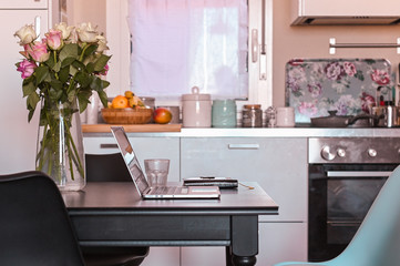 Computer on the table in the kitchen. Work at home and freelance. Cozy home. Free space for text.