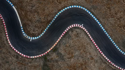 Deurstickers Gebogen racebaanweergave van bovenaf, luchtfoto autorace asfaltbaan en curve. © Kalyakan