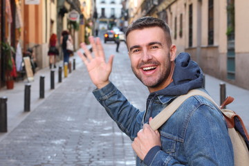 Man saluting someone he knows outdoors 