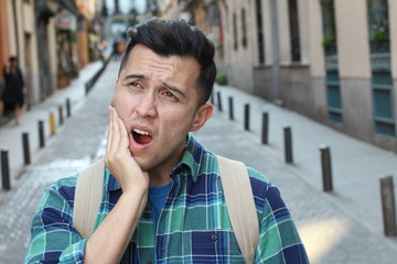 Guy experimenting intense toothache outdoors 