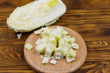 Chopped chinese cabbage on cutting board on wooden table