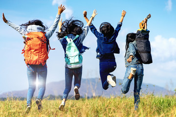 Trekking holiday concept.Four women are trekking in the mountains with backpack,tent,hiking...