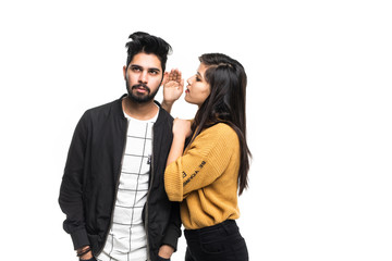 Beautiful indian woman whispering to boyfriends ear isolated on white background