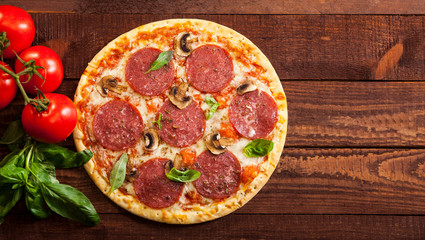 Pepperoni pizza on rustic, vintage style wood background. Top view