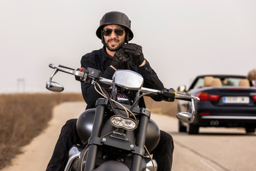  Handsome man on a black classic motorcycle