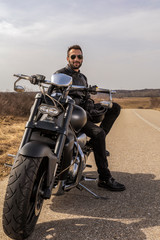  Handsome man on a black classic motorcycle
