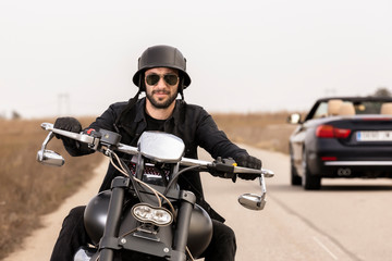  Handsome man on a black classic motorcycle