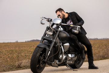 Fototapeta na wymiar Handsome man on a black classic motorcycle