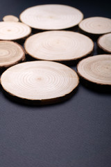 Pine tree cross-sections with annual rings on plane black surface. Lumber piece close-up shot.