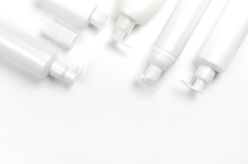 White cosmetic bottle containers on white background top view flat lay with space for text. Cosmetics SPA branding mock-up, Natural organic beauty product concept, Minimalism cosmetics style