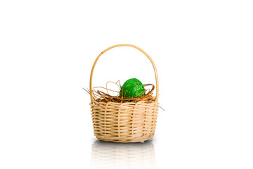 Fototapeta na wymiar Easter egg with glitter green color in the nest on wooden basket