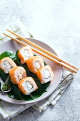 Philadelphia roll classic on a plate with chopsticks. Japanese sushi food. Copy space