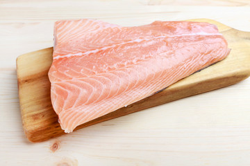 Raw salmon filet on wooden background