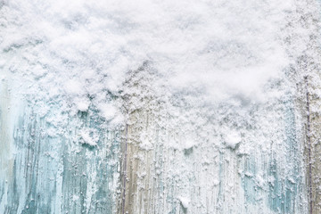 Real, natural snow on blue wooden background.