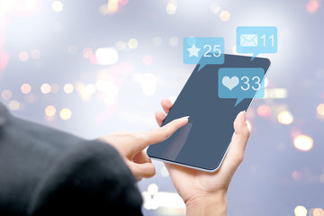 Business woman touching the tablet screen with notification of message, likes and important things