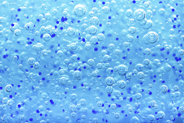 Transparent gel with bubbles close-up. The texture of gel cream. Oxygen bubbles in clear blue...