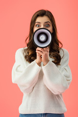 Fototapeta premium brunette woman in white sweater screaming in megaphone isolated on pink