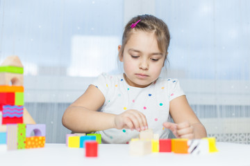 Children play with educational toy on table in the children's room. Two kids playing with colorful blocks. Kindergarten educational games