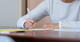 Woman write on note paper at home