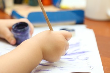 Childs hand with a paintbrush 