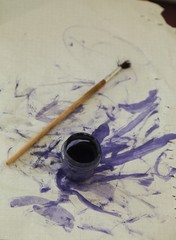 Jar of purple paint and paintbrush 