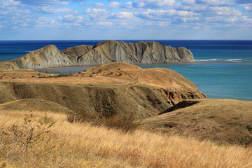 Beautiful autumn landscape near Koktebel in Crimea. Yellow hills and mountains by the blue sea
