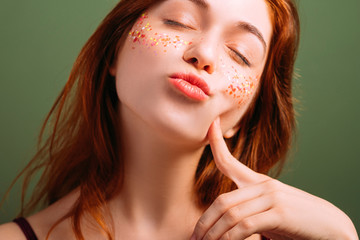 Young beautiful female portrait. Woman self esteem. Pout lips blowing kiss. Finger at cheek. Closed eyes.