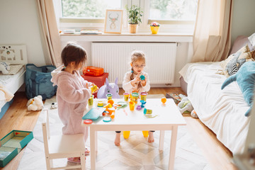 two little girls play in nursery with play dough